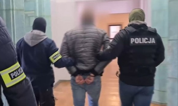 policjanci prowadzą zatrzymanego