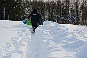 Dzielnicowy, żołnierz WOT, mężczyzna niosą torby przez zaśnieżone pole