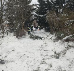 policjanci pomagają starszym osobom - odśnieżają drogę