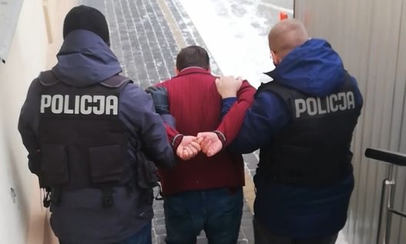 Dwaj policjanci prowadzą zatrzymanego