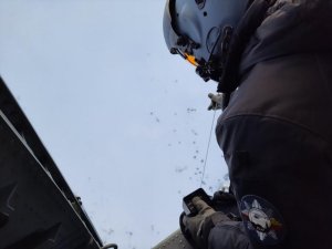 Policjnat wciąga kobietę na pokład helikoptera