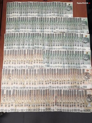 Zabezpieczona przez policjantów gotówka - banknoty rozłożone są na biurku