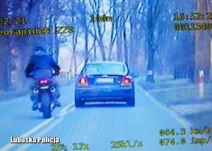 Motocyklista wyprzedza auto na podwójnej linii ciągłej