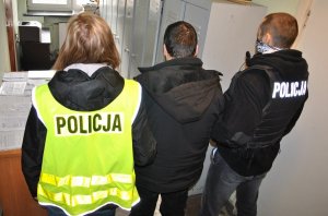 Policjanci prowadzą zatrzymanego mężczyznę