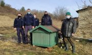 czterej umundurowani policjanci, pracownik Ogólnopolskiego Towarzystwa Ochrony Zwierząt i pies stoją koło budy