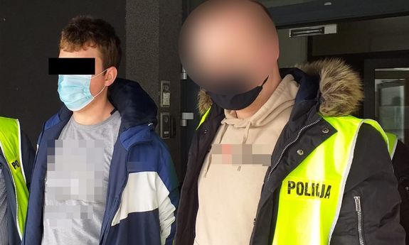 Zatrzymany mężczyzna prowadzony przez policjantów w żółtych kamizelkach z napisem Policja