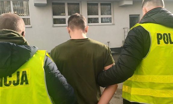 policjanci w żółtych kamizelkach z napisem Policja prowadzą zatrzymanego