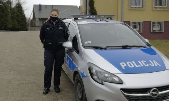 umundurowana policjantka, która uratowała kobietę z zamarzniętego stawu, stoi przy radiowozie