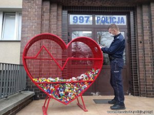 policjant wrzucający nakrętki do serduszka