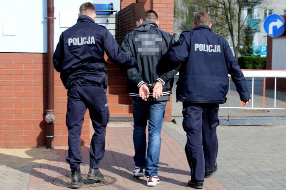 dwaj policjanci prowadzą zatrzymanego