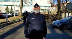 Umundurowany dowódca katowickiego oddziału prewencji Policji, za nim widoczni policjanci stojący w szyku