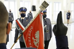 Policjant ślubuje na sztandar przed pocztem sztandarowym