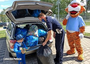 Policjant pakuje nakrętki do radiowozu
