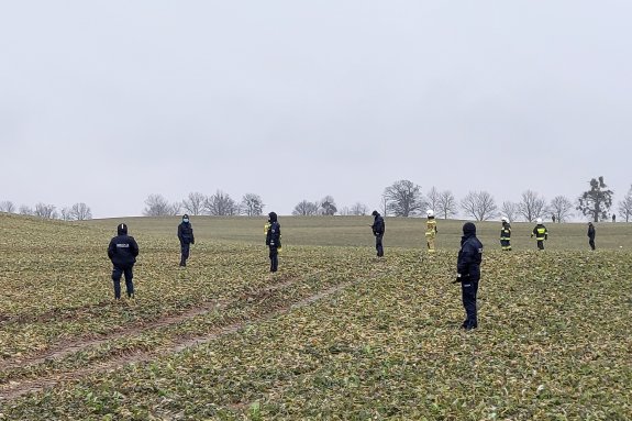 Rząd policjantów i strażaków stoi na polu gotowi do poszukiwań&quot;&gt;