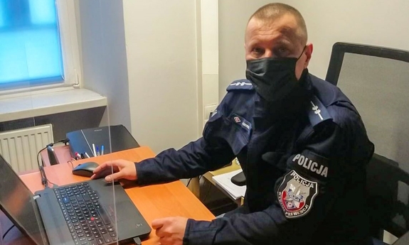 policjant siedzi przy biurku