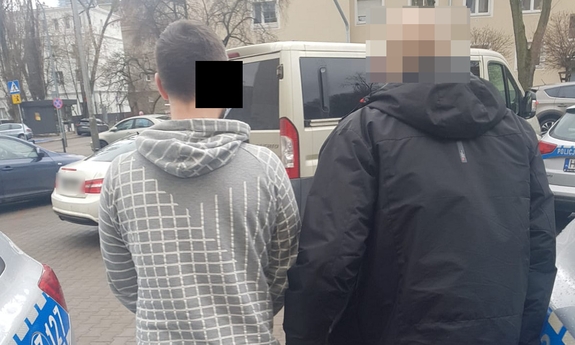 policjant prowadzi zatrzymanego mężczyznę