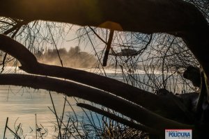 lecący policyjny śmigłowiec nabiera wodę do podczepionego zbiornika, tzw. Bambi Bucket