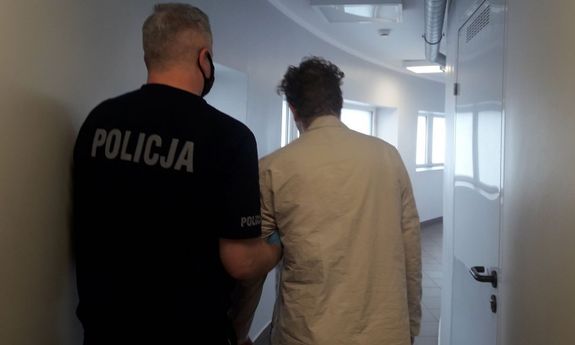 Policjant prowadzi zatrzymanego