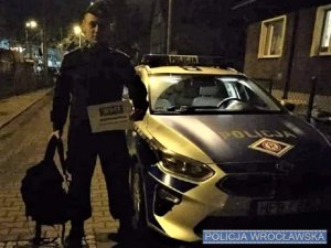 policjant z trofeami stoi koło radiowozu