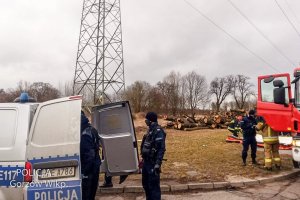 policjanci przy radiowozie policyjnym i wóz strażacki