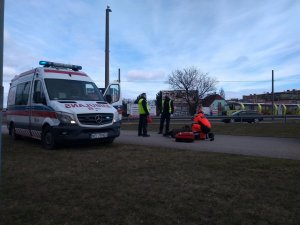 karetka pogotowia, obok ratownicy i policjanci podczas udzielania pomocy