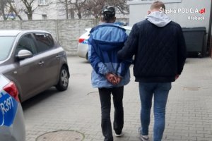 policjant prowadzi zatrzymanego mężczyznę