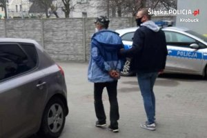 policjant prowadzi zatrzymanego mężczyznę