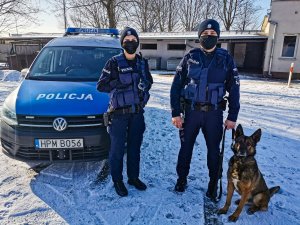 po lewej stronie umundurowana policjantka, obok niej przewodnik psa służbowego  oraz policyjny pies