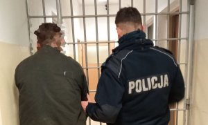 policjant prowadzi zatrzymanego mężczyznę