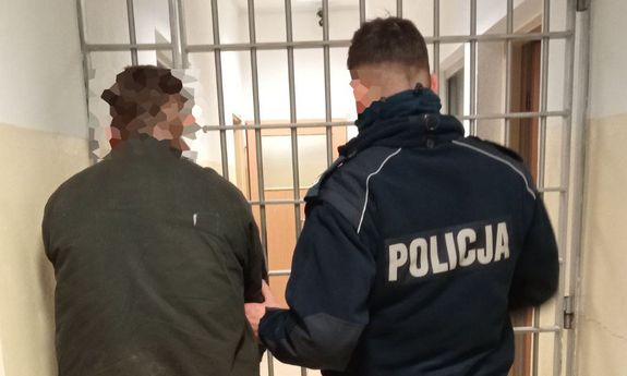 policjant prowadzi zatrzymanego mężczyznę