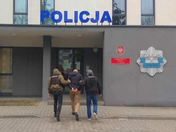 policjanci prowadzą zatrzymanego do komisariatu