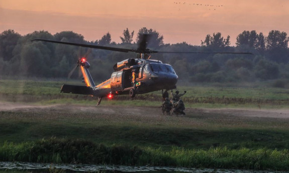 Helikopter lądujący na łące by zabrać policyjnych kontrterrorystów