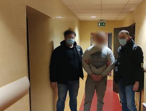dwaj policjanci prowadzą zatrzymanego