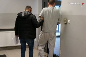 policjant prowadzi zatrzymanego mężczyznę