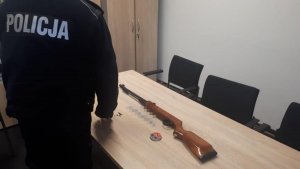 policjant stoi przy stole na którym leży wiatrówka