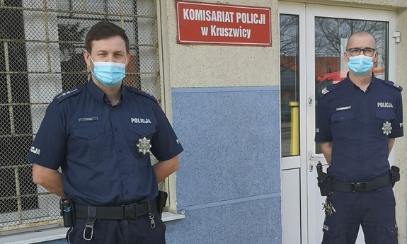 dwaj policjanci stoją przed budynkiem komisariatu