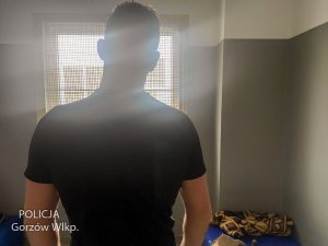 zatrzymany mężczyzna w celi - widok z tyłu