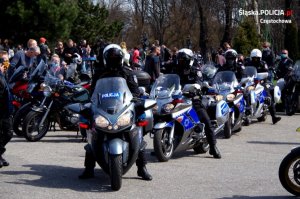 4 policjantów w rzędzie stoi na parkingu