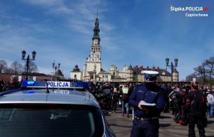 policjant w białej czapce na tle Jasnej Góry pisze w notatniku