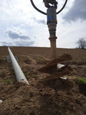 Zbliżenia na świder. W tle leży betonowy słup energetyczny.
