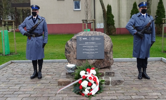 dwaj policjanci stoją na warcie przy obelisku poświęconym trzem funkcjonariuszom Policji Państwowej