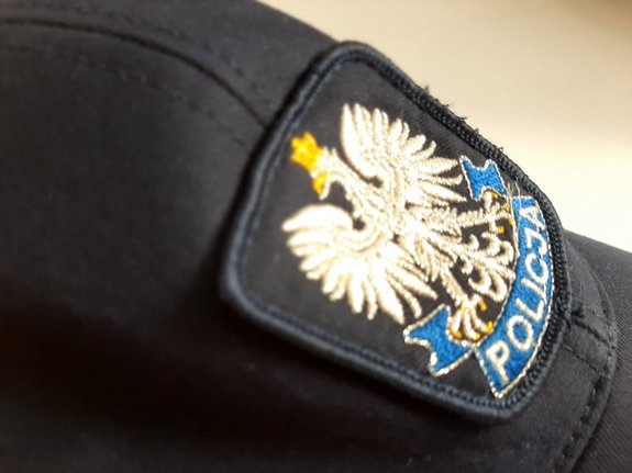 Policyjna czapka z daszkiem. Na środku znajduje się orzeł, a pod nim napis Policja