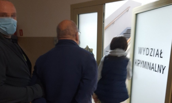 policjant prowadzi zatrzymanego mężczyznę