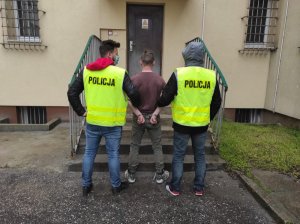 dwaj policjanci prowadzą zatrzymanego