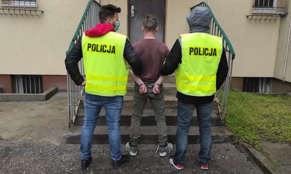 dwaj policjanci prowadzą zatrzymanego