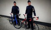 Dwaj umundurowani policjanci stoją przy rowerach