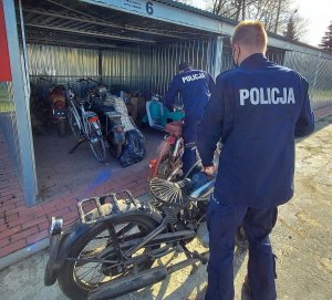 policjanci wstawiają do garażu motocykle