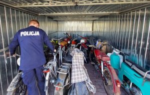 policjanci wstawiają do garażu motocykle