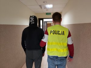 policjant prowadzi zatrzymanego mężczyznę&quot;&gt;