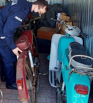 policjant w garażu ogląda motocykle